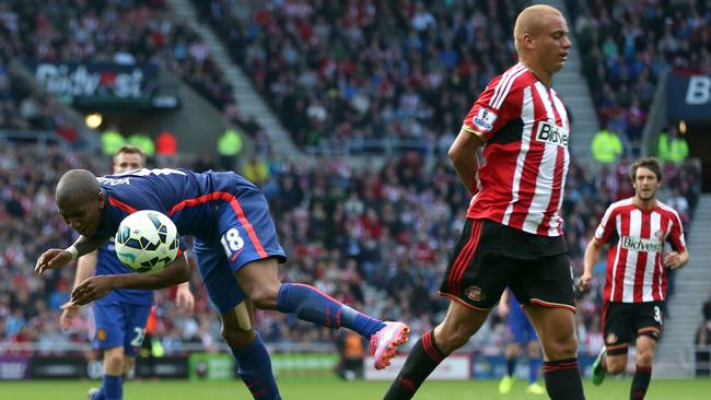 Manchester United's English midfielder Ashley Young falls to the ground.