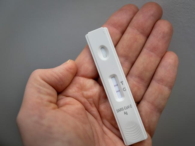 A used rapid antigen test, also known as a lateral flow test showing a positive test result for the Covid-19 coronavirus is photographed in Berlin on January 22, 2022. - Taking a test involves doing swab from inside your nostril or in your throat, depending on the test you are using, before mixing the swab with solution and dripping it onto a container with a test strip with antibodies specific to the Covid-19 virus painted on it in a thin line. If the testing strip detects the virus, it shows up as a red line next to the âTâ on the container, the line next to the âCâshould always be visible. (Photo by Odd ANDERSEN / AFP)