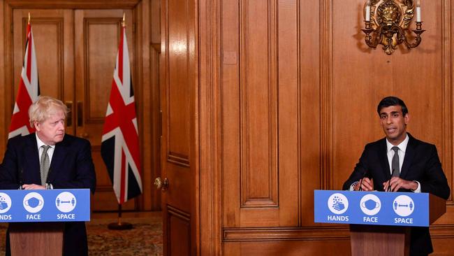 Boris Johnson (L) listens as Britain's Chancellor of the Exchequer Rishi Sunak announces the new restrictions. Picture: Getty Images.