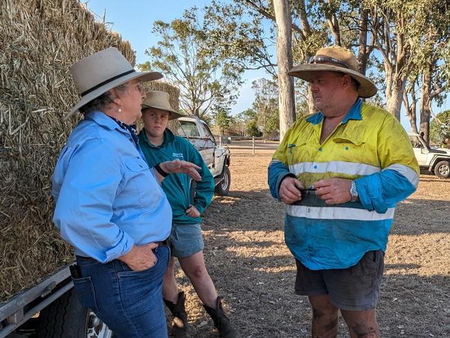 Farmer picking up hay at fodder drop (Ban Ban) with AgForce Georgie Somerset as Emergency fodder provides relief for bushfire-hit primary producers. Picture: Supplied by QLD Government