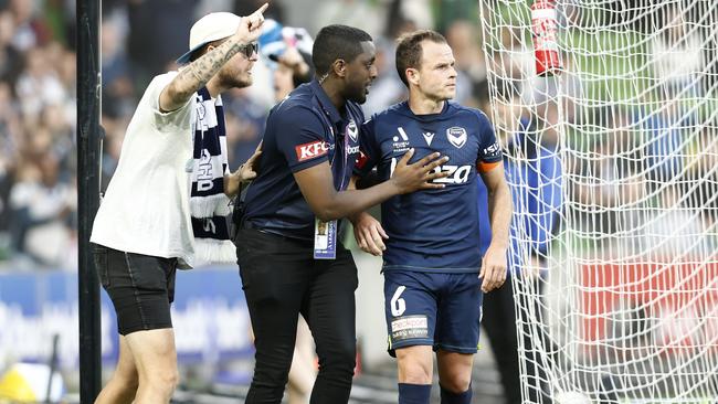 Leigh Broxham of Melbourne Victory is escorted from the pitch.