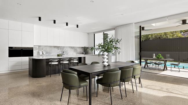 Plush textures, polished concrete floors, and expansive glazing define this living space.