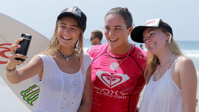 Evans Head sisters Tiana, 15, and Nikki Clark pose for a selfie with Tyler Wright. Action at the Roxy Pro at Snapper Rocks. Pics Tim Marsden