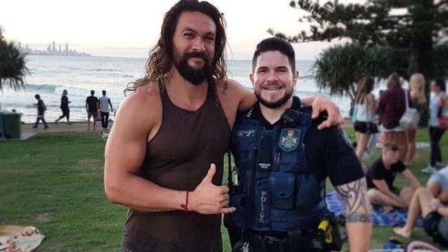 Aquaman star Jason Momoa with a police officer at Burleigh. Photo: QPS Twitter