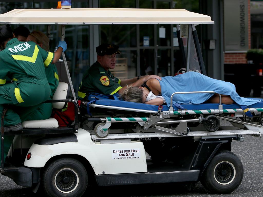 Paramedics stretcher a girl to a medical tent at Festival X.