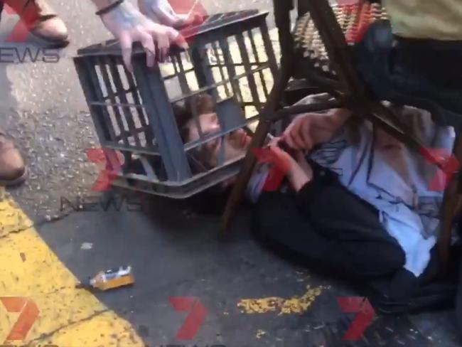 The man was locked down on the ground by the crate and chair, unable to escape. Picture: Seven News