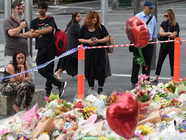 People pause at the flower memorial this morning to pay tribute. Picture: Nicole Garmston