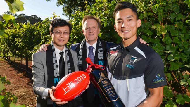 Swan Wine Group managing director Li Wei (left) with Port Adelaide CEO Keith Thomas and player Chen Shaoliang. Swan Wine Group — a wine group sponsor of Port Adelaide — paid $1.8 million for a winery operation in Tanunda in 2014. Picture: AAP Image/ Brenton Edwards