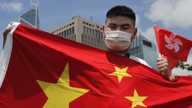 A pro-China supporter holds a Chinese and Hong Kong national flag during a rally to celebrate the approval of a national security law for Hong Kong. Picture: AP