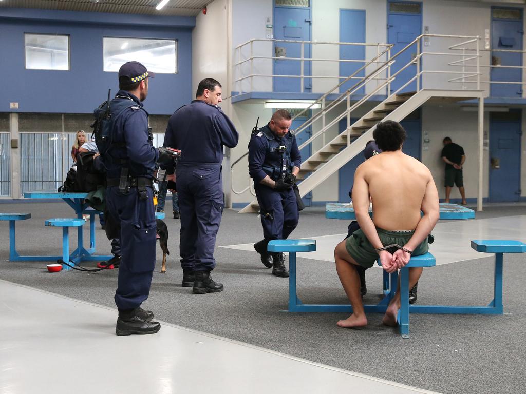 An inmate is interviewed by Corrective Services officers following the discovery of drugs in his cell during a raid on cells at Silverwater Jail. The officers now wear body cams that record the raids. Picture: Richard Dobson