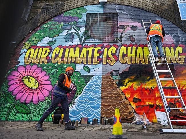 Artists paint a mural on a wall in Glasgow ahead of the COP26 UN Climate Summit later this month.