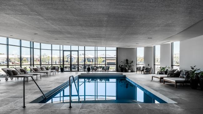 Floor to ceiling glass surrounds the pool.