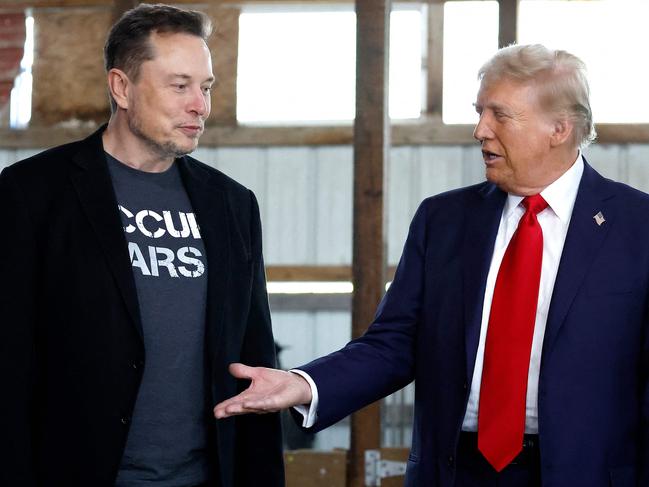 (FILES) Republican presidential nominee, former President Donald Trump offers his hand to Tesla and SpaceX CEO Elon Musk back stage during a campaign rally at the Butler Farm Show grounds on October 05, 2024 in Butler, Pennsylvania. US President-elect Donald Trump on November 12, 2024, said Tesla and SpaceX CEO Elon Musk will lead a so-called Department of Government Efficiency alongside US entrepreneur Vivek Ramaswamy. (Photo by Anna Moneymaker / GETTY IMAGES NORTH AMERICA / AFP)