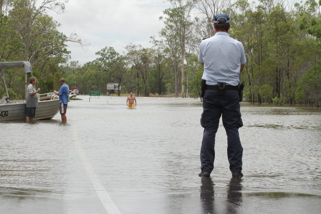 A police officer questioned a man swimming in flooded Saltwater Creek. Photo: Robyne Cuerel / Fraser Coast Chronicle. Picture: Robyne Cuerel