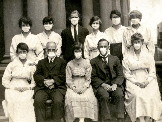 Masked figures at Sydney Town Hall during the height of the epidemic. Picture: City of Sydney Archives