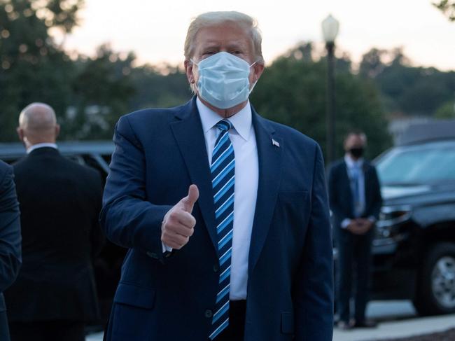 TOPSHOT - US President Donald Trump gives the thumbs-up as he leaves Walter Reed Medical Center in Bethesda, Maryland heading towards Marine One on October 5, 2020, to return to the White House after being discharged. - Trump announced Monday he would be "back on the campaign trail soon", just before returning to the White House from a hospital where he was being treated for Covid-19. (Photo by SAUL LOEB / AFP)