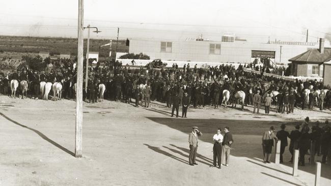 The aftermath of the second riot — strikers form a loose crowd while mounted police stand by. Outer Harbor buildings and the sea can be seen in the distance. Picture: State Library of South Australia