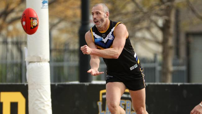 Stephen Brewer fires off a handball for Caroline Springs. Picture: Local Legends Photography