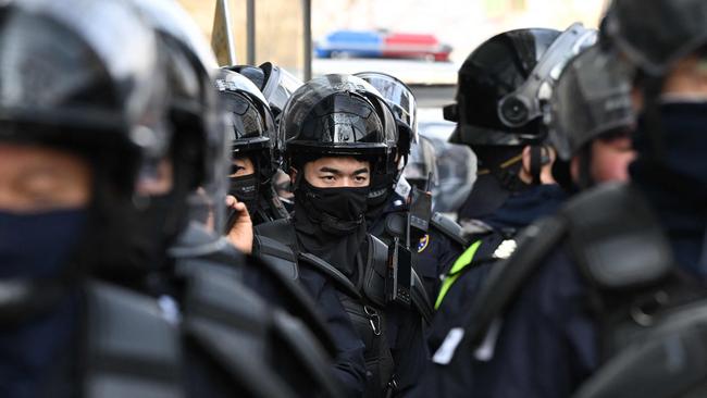 Riot police stand on the road near the Constitutional Court in Seoul ahead of the ruling. Picture: AFP.
