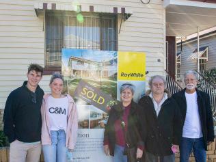 The young couple who successfully bid for 15 Victoria Street (left) with the seller's family (right).