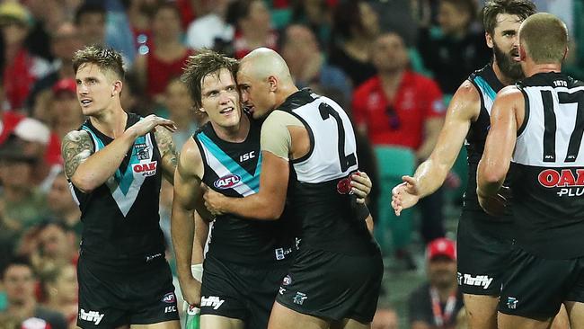 Port Adelaide's Jared Polec celebrates kicking a goal with teammates Hamish Hartlett and Sam Powell-Pepper. Picture. Phil Hillyard