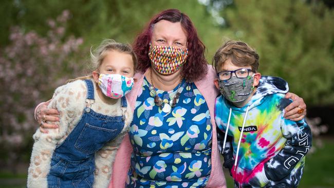 Former schoolteacher Ann Mushet has been making kids masks in Minecraft and puppy designs. Ann is with siblings, Millie, 8 and Jack Tew, 10 wearing her masks. Picture: Sarah Matray