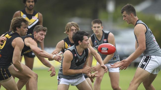 Mitchell Marini gets a handball away for Uni. Picture: Dean Martin