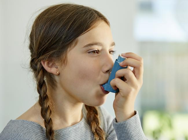 Close-up of girl using asthma inhaler at home. Little girl is suffering from health issues. She is looking away while taking dose. Picture: Istock