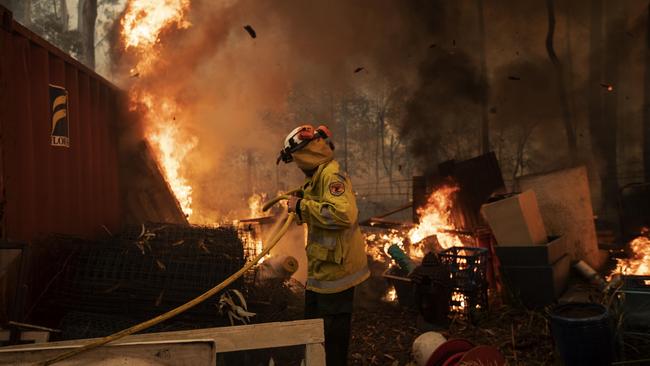 A firefighter defends a property during the Currowan bushfires on the NSW south coast. Picture: Gary Ramage