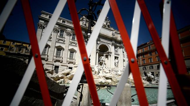 A deserted Trevi Fountain is pictured through a barrier in central Rome. Picture: AFP