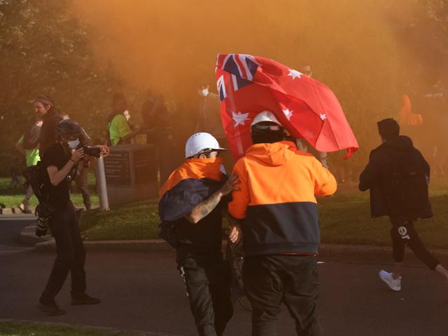 Construction workers and demonstrators react after police fire tear gas around the Shrine of Remembrance during a protest on Wednesday. Picture: Con Chronis/AFP