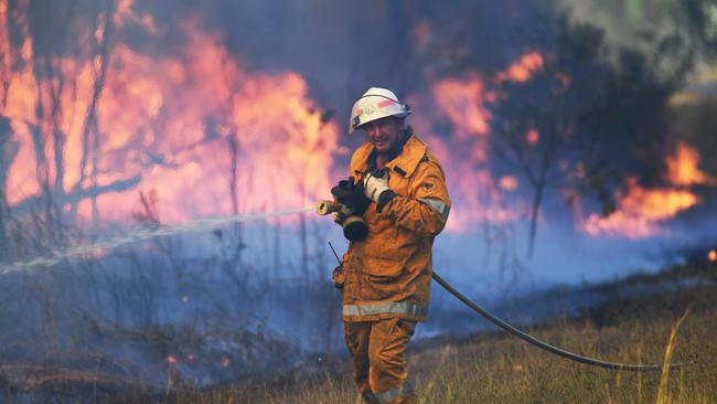 A rural firefighter battles a blaze at Rockhampton.