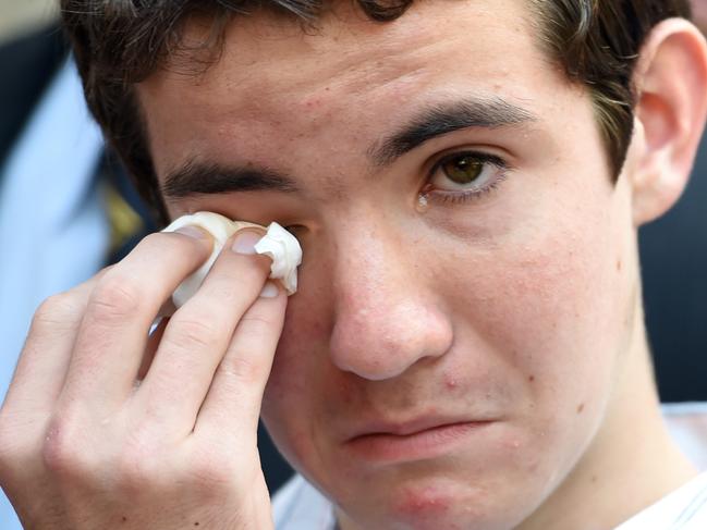 Cain, the son of NSW police officer Bryson Anderson, wipes his eyes as he leaves NSW Court of Criminal Appeal in Sydney on Monday, Dec. 12, 2016. Mitchell Barbieri, was originally handed a minimum 26-year sentence for the stabbing murder of Inspector Bryson Anderson, had 11 years cut from his non-parole period, re-sentenced to at least 15 years' jail, with a maximum term of 21 years. (AAP Image/Paul Miller) NO ARCHIVING