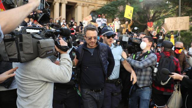 Police lead the man away from the protest. Picture: Tim Hunter