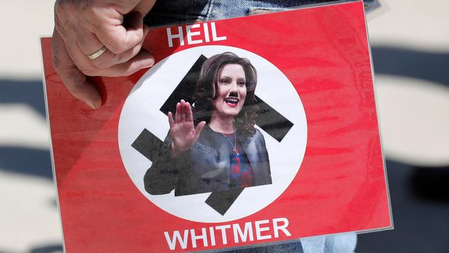 A demonstrator carries a protest poster of Gretchen Whitmer in Lansing, Michigan, in May. Picture: AFP