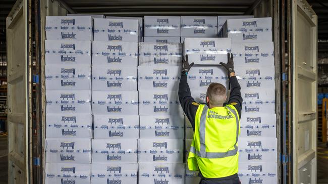 Australian Border Force officer Jake removes boxes of illegally imported cigarettes out of a shipping container. Picture: Jake Nowakowski