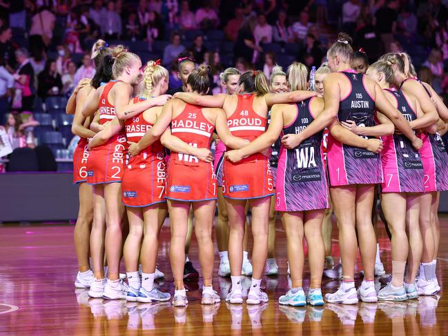 The Thunderbirds and Swifts embrace as their match is abandoned due to a power issue during the round two Super Netball match at Netball SA Stadium on March 25, 2023. Picture: Graham Denholm/Getty Images.