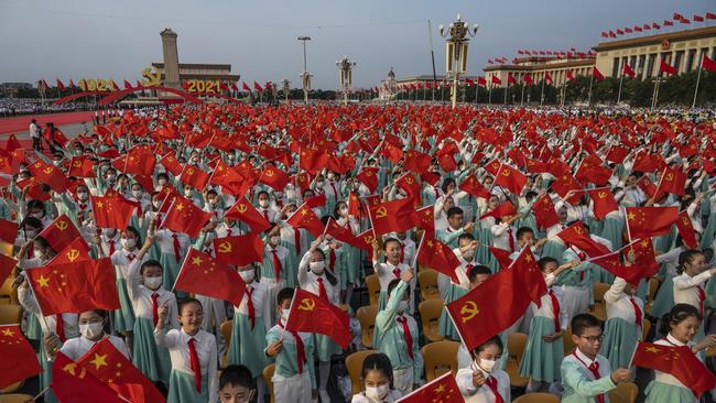 Chinese students wave party and national flags at a ceremony marking the 100th anniversary of the Communist Party at Tiananmen Square on July 1 in Beijing. Picture: Getty