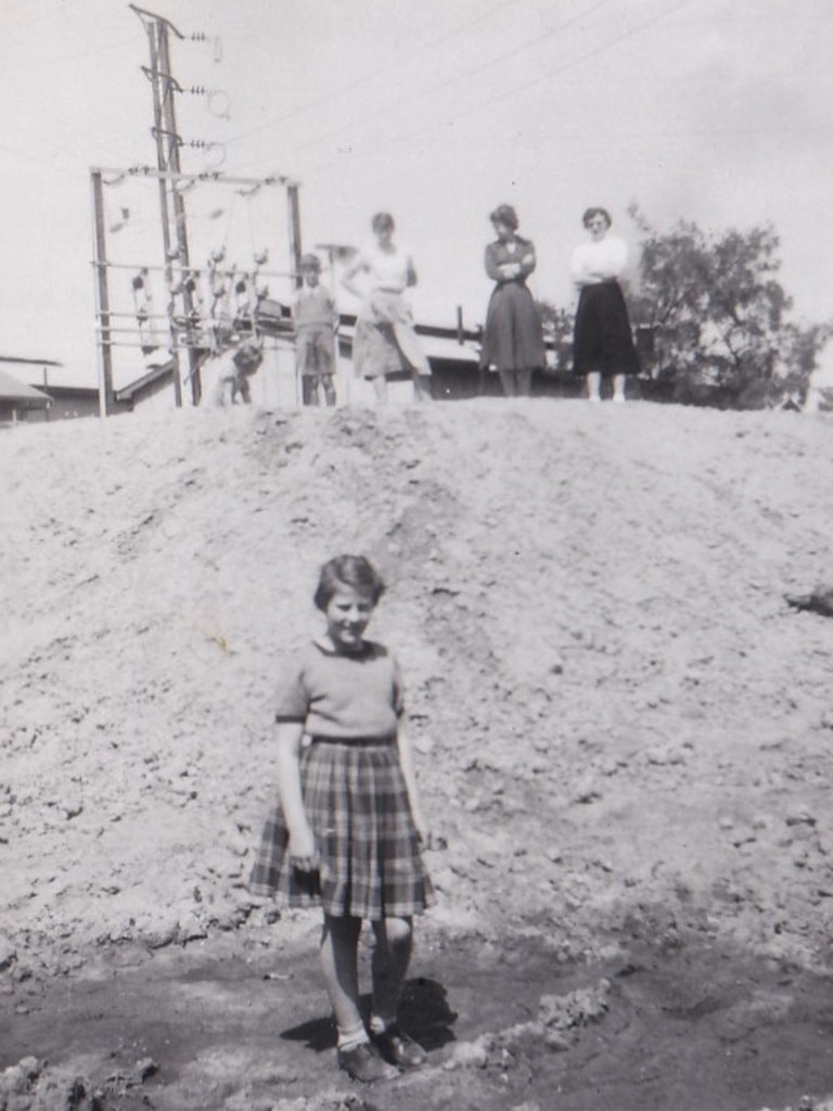 Pamela Phillips stands in front of a levee around the Berri power station in October 1956, after the peak of the River Murray flooding. Picture: Supplied by Anita Woods