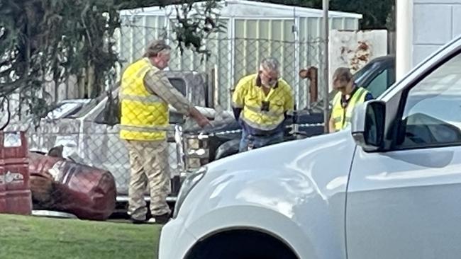 Workplace Health and Safety officers examine the site where a man in his 20s was critically injured in a small explosion.