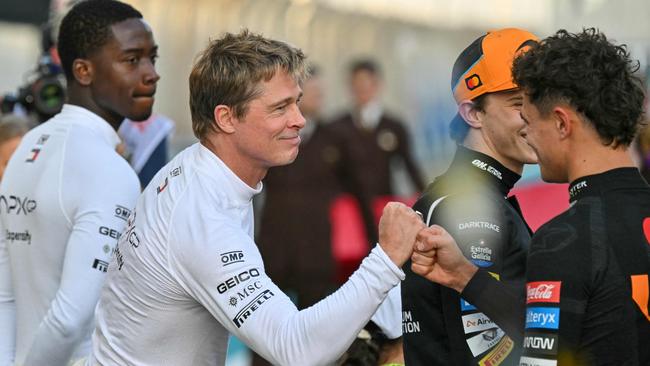 Brad Pitt greets Lando Norris on the grid. (Photo by Andrej ISAKOVIC / AFP)