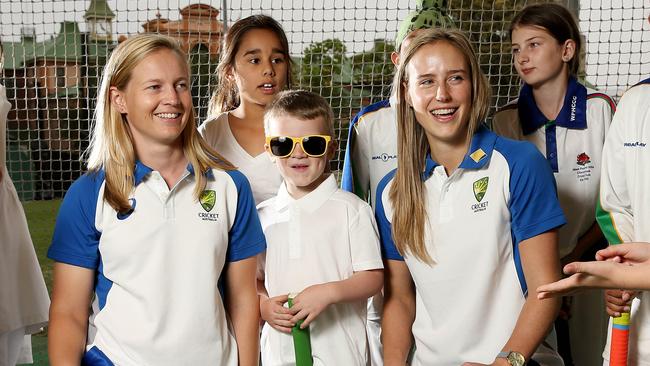Meg Lanning (L) and Allyse Perry with young cricketers.