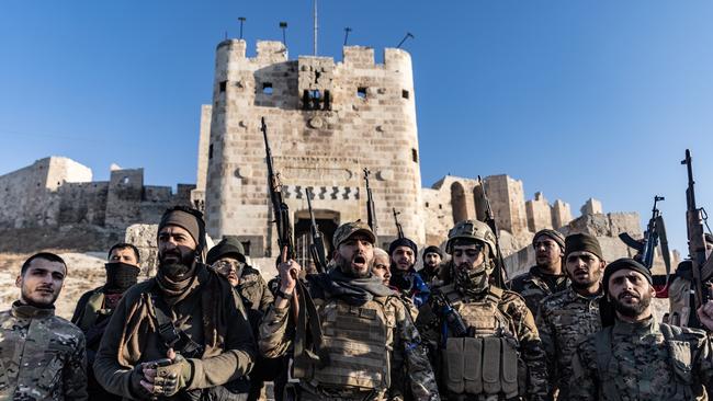 Members of the Syrian armed opposition forces stand in front of the Ancient Castle of Aleppo after seizing control of most parts of Syria's second largest city. Picture: Getty Images