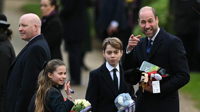 Prince William and his children Prince George and Princess Charlotte hold gifts from wellwishers after attending the Royal Family's traditional Christmas Day service at St Mary Magdalene Church in Sandringham, Norfolk. Picture: AFP.