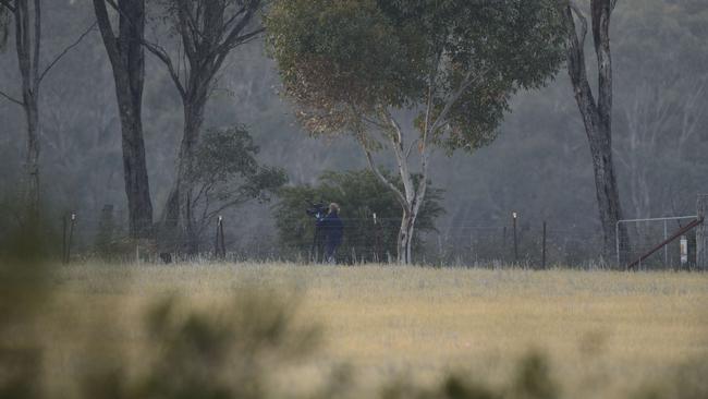 One body was found in a paddock. Police collect evidence. Picture: Daryl Pinder