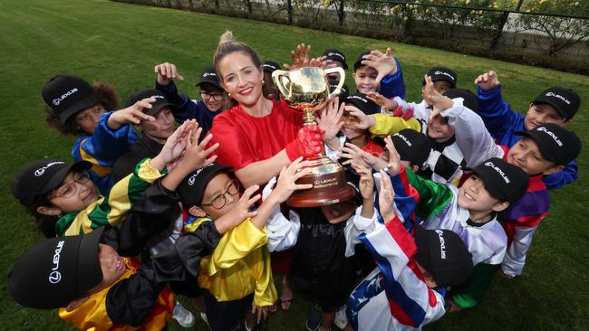 Melbourne Cup jockey Michelle Payne holds up the Lexus Melbourne Cup from students from St Margaret’s Primary School, Maribyrnong. Picture: David Caird