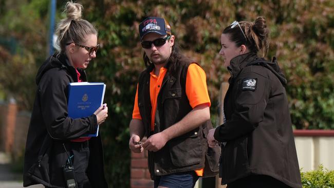 Police talk to a neighbour after the house fire in Werribee. Picture: Luis Enrique Ascui