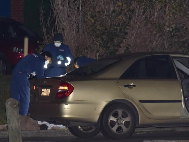 Police inspect a car at the scene of a shooting in Millewa Cresent in Dallas. Picture: Ellen Smith