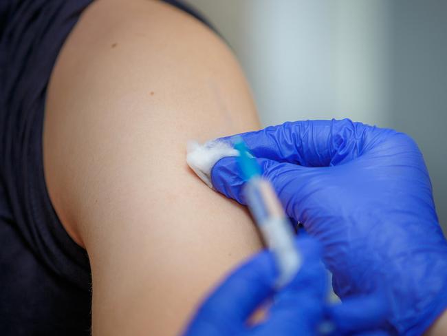 Vaccine injection. Syringe with medicine in the hands of a doctor in blue gloves. Prophylaxis and treatment of infectious and viral diseases. Inoculation against influenza. Vaccination against rabies.