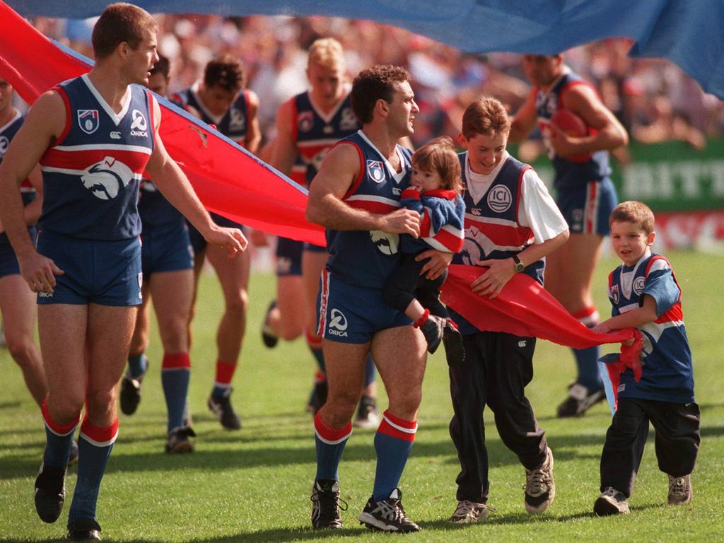 Tom Liberatore (far right) runs out onto the ground with dad Tony, sister Meg, and brother Christopher to celebrate Tony’s 200th game in 1998.